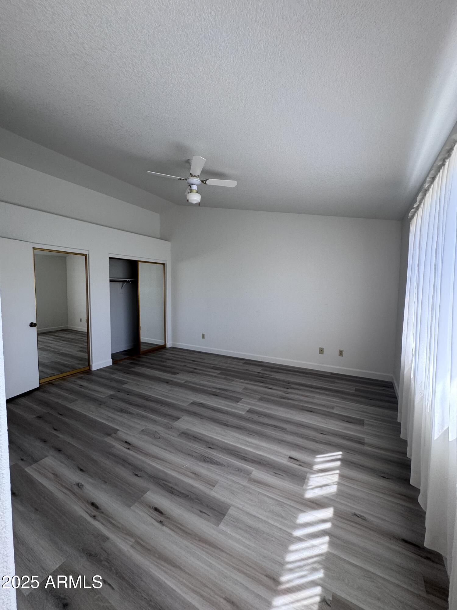 8631 West Monte Vista Road Phoenix, AZ 85037 - Photo 14 of 26 wooden floor in an empty room with a window
