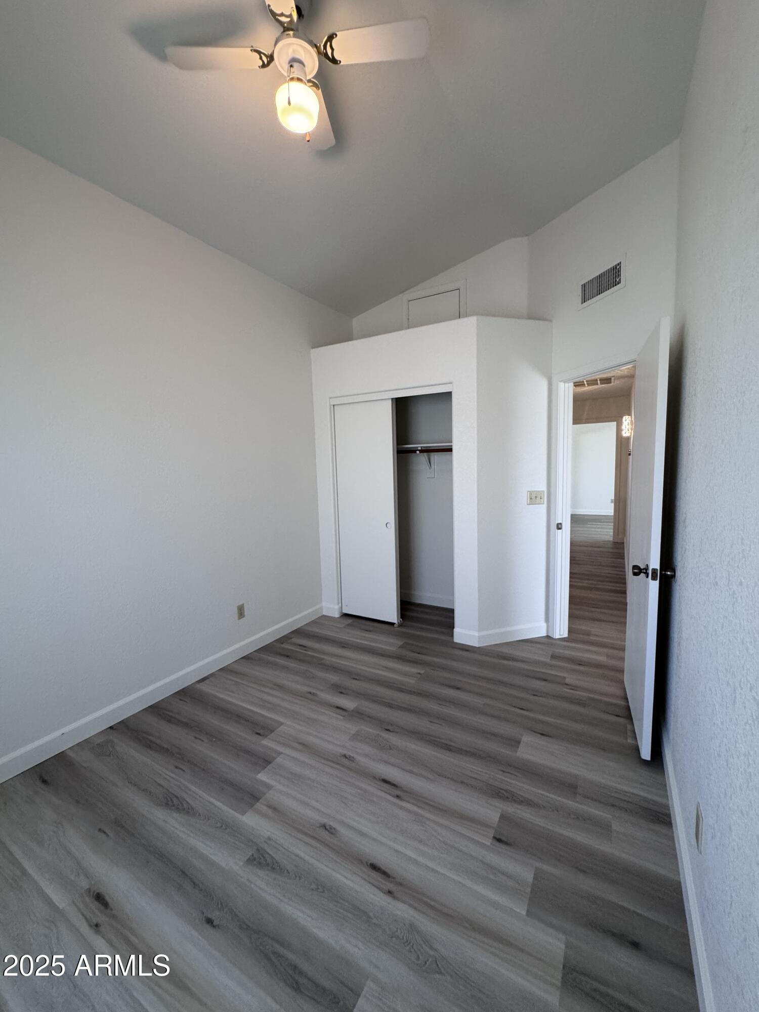 8631 West Monte Vista Road Phoenix, AZ 85037 - Photo 22 of 26 a view of a livingroom with wooden floor and a ceiling fan