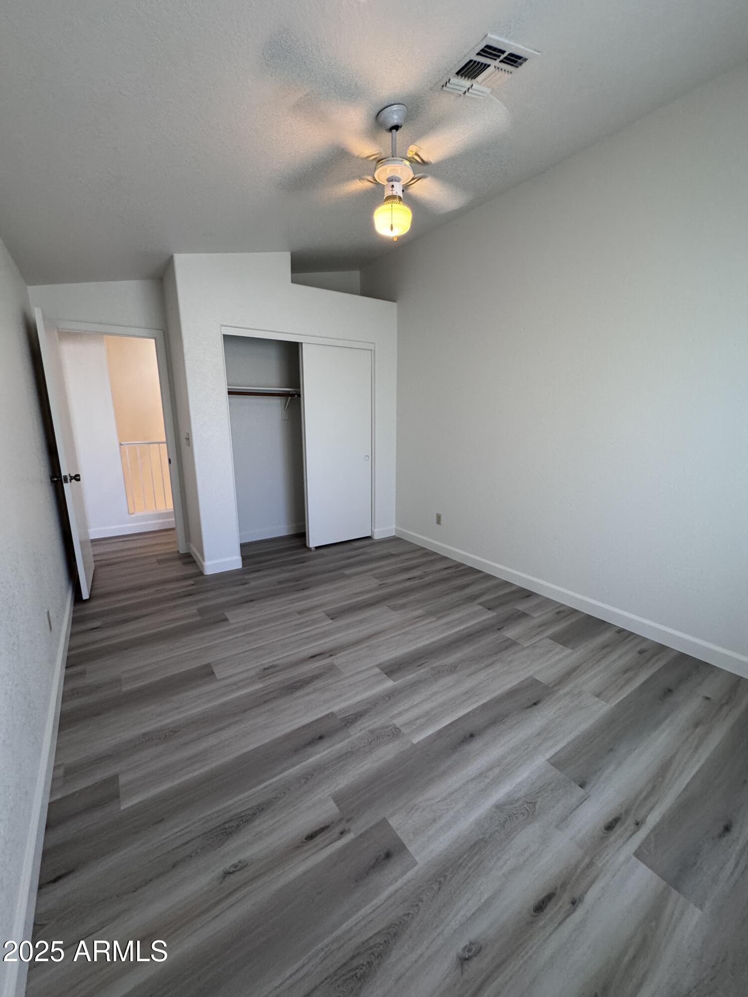 8631 West Monte Vista Road Phoenix, AZ 85037 - Photo 24 of 26 a view of an empty room with wooden floor and a fireplace