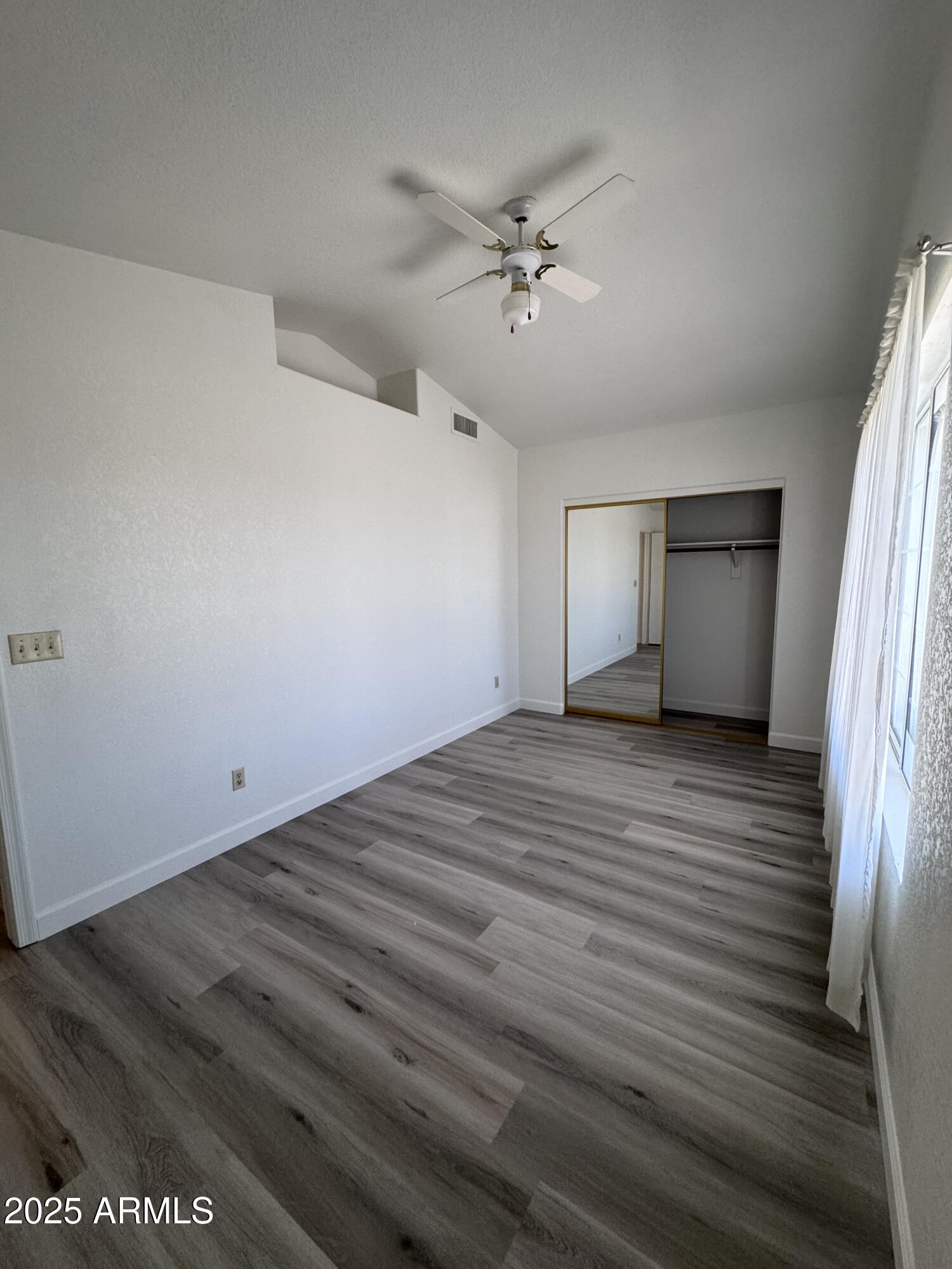 8631 West Monte Vista Road Phoenix, AZ 85037 - Photo 26 of 26 a view of empty room with wooden floor and fan