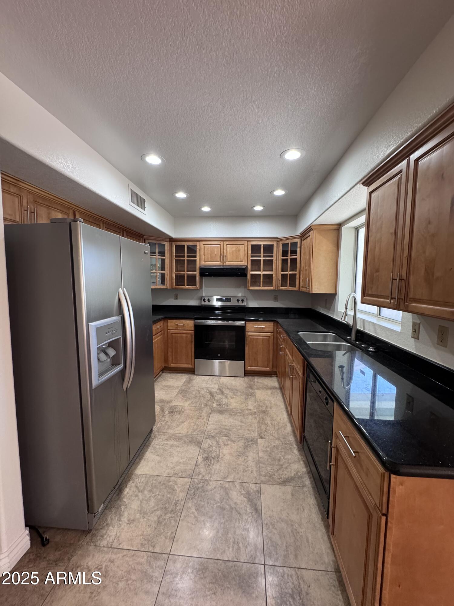 8631 West Monte Vista Road Phoenix, AZ 85037 - Photo 5 of 26 a large kitchen with stainless steel appliances granite countertop a refrigerator and a sink