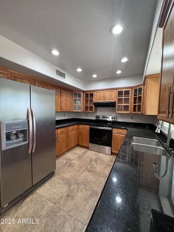 a kitchen with stainless steel appliances granite countertop a sink and a refrigerator