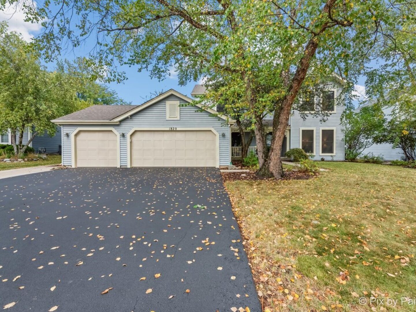 a front view of a house with a yard and trees