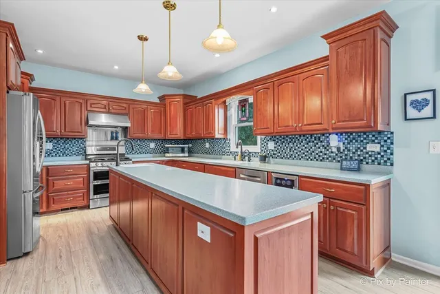 a kitchen with a sink a counter space appliances and cabinets