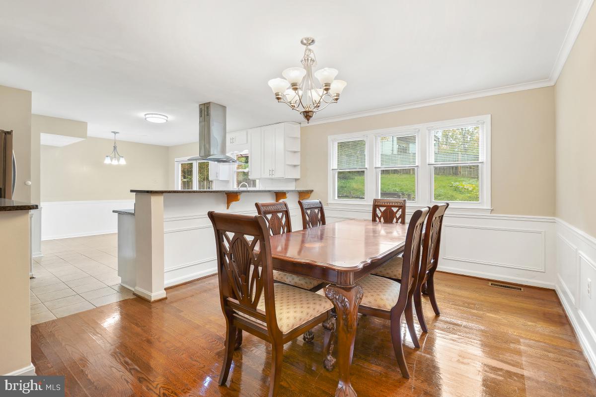 6871 Churchill Road McLean, VA 22101 - Photo 8 of 30 a view of a dining room with furniture a chandelier and wooden floor