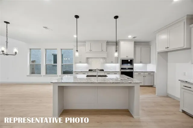a kitchen with stainless steel appliances kitchen island granite countertop a stove a sink and a refrigerator