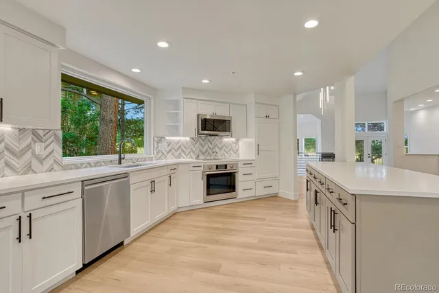 a large white kitchen with a large window