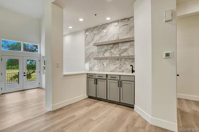 a view of kitchen with a sink wooden cabinets and window