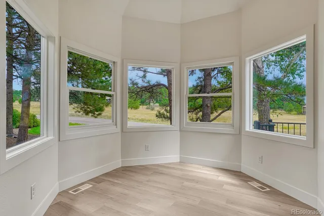 an empty room with wooden floor and a window