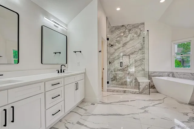 a bathroom with a granite countertop sink mirror bathtub shower and toilet