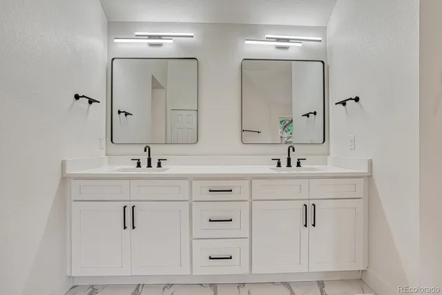 a bathroom with double vanity sink and a mirror