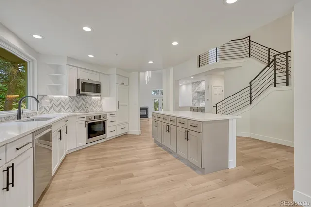 a kitchen with stainless steel appliances kitchen island granite countertop a stove a sink and a refrigerator