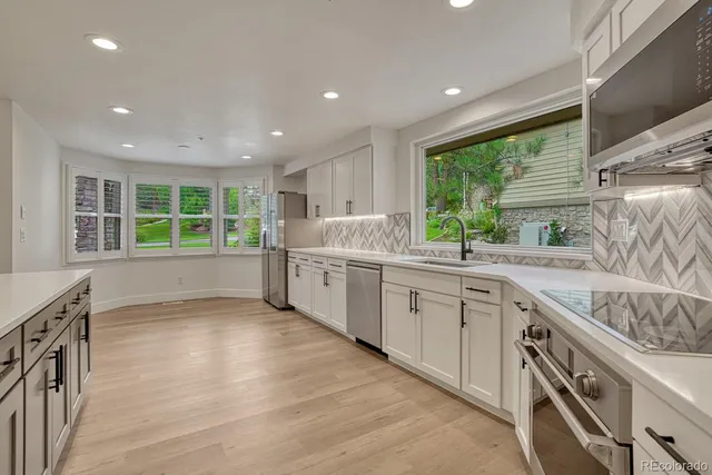 a kitchen with stainless steel appliances granite countertop a sink and window