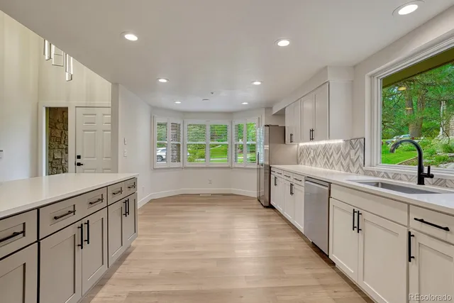 a large white kitchen with a large window