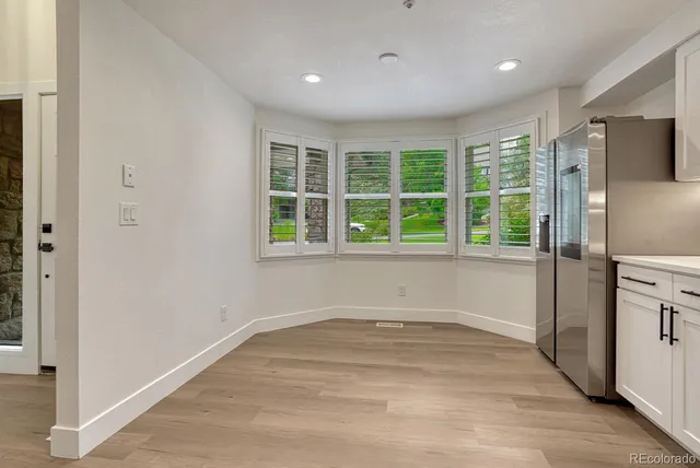 a view of empty room with a window and wooden floor