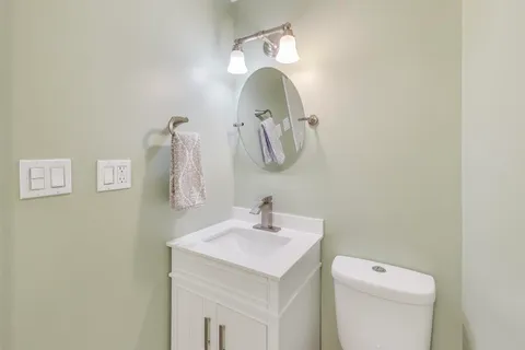 a bathroom with a sink and mirror with toilet