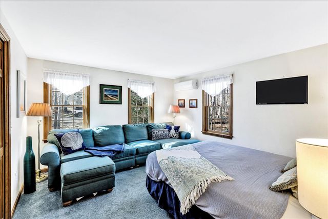 a spacious bedroom with a bed and a flat screen television