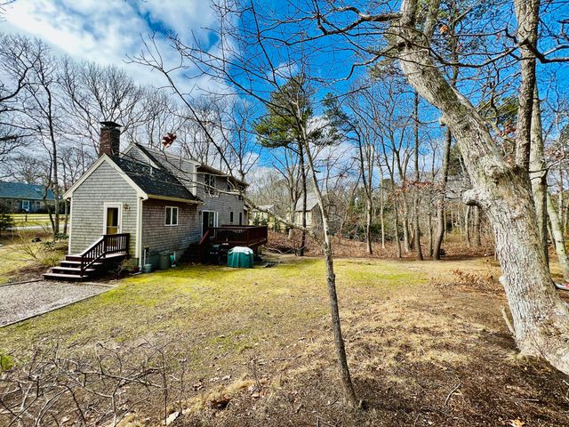 a view of a white house with a yard covered in snow