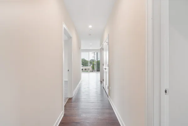 a view of a hallway with wooden floor