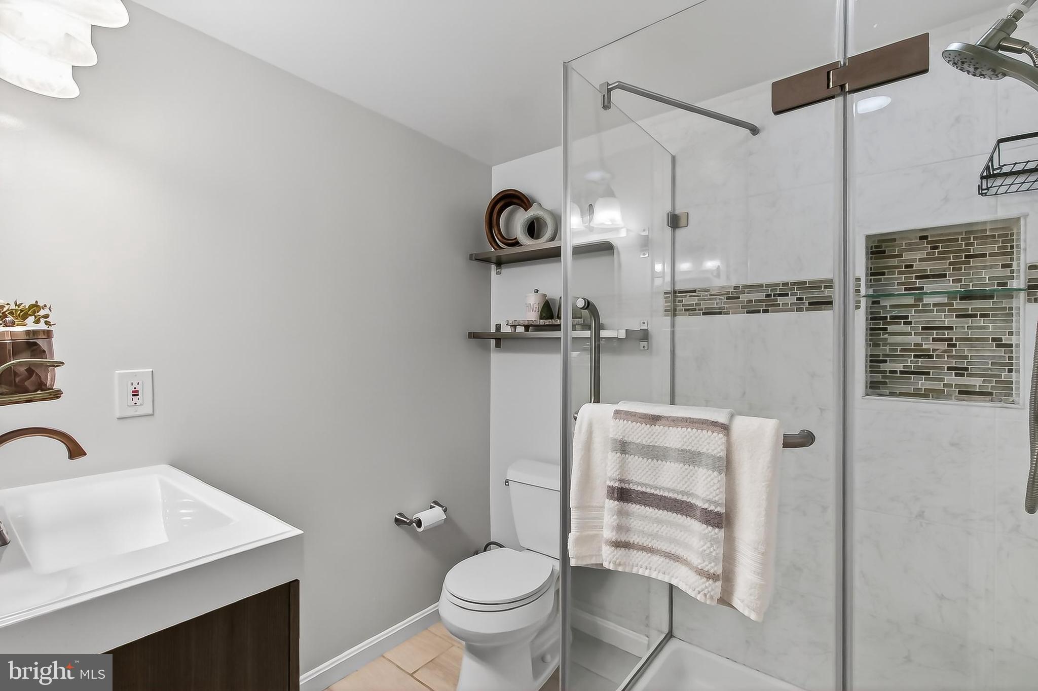 5833 Royal Ridge Drive, Unit 943 Springfield, VA 22152 - Photo 36 of 45 a bathroom with a sink toilet and shower