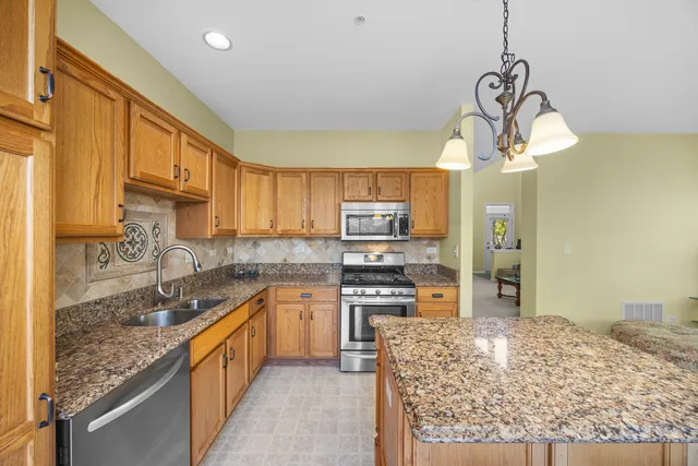 a kitchen with stainless steel appliances granite countertop a sink stove and refrigerator