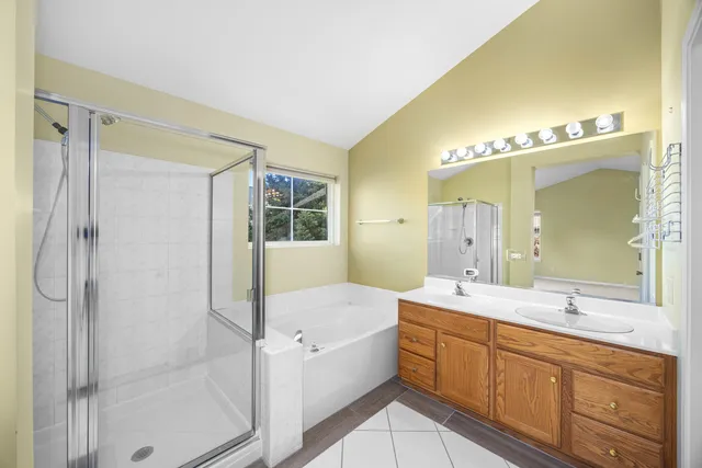 a bathroom with a tub sink shower and mirror