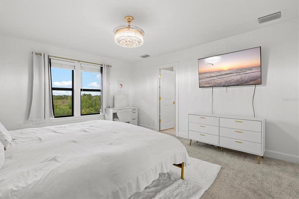 16235 Pine Mist Drive Bradenton, FL 34211 - Photo 23 of 100 a bedroom with a bed and a flat tv screen on dresser