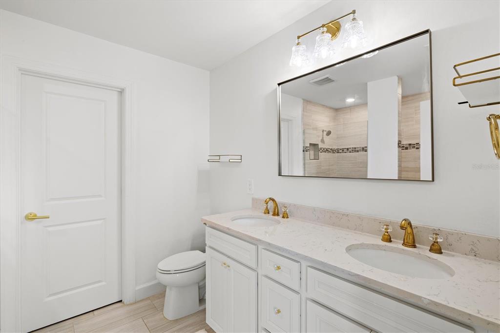 16235 Pine Mist Drive Bradenton, FL 34211 - Photo 26 of 100 a bathroom with a toilet sink vanity and mirror