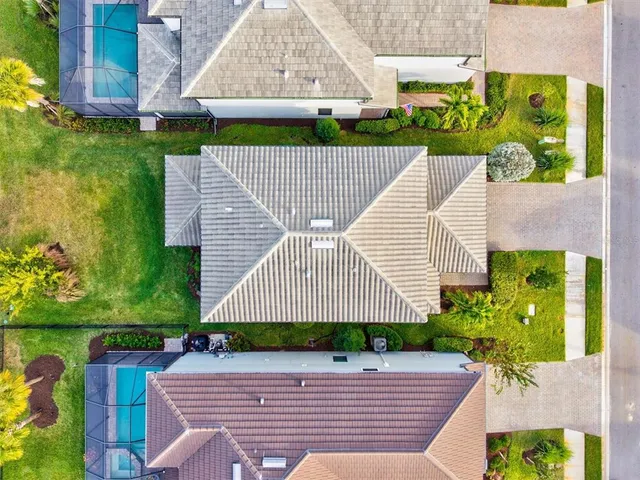 an aerial view of a house with a swimming pool and outdoor seating