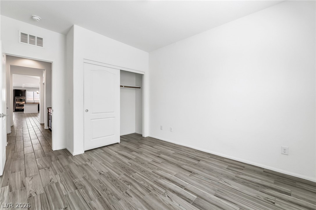 6245 Andover Wood Road Las Vegas, NV 89113 - Photo 29 of 37 A well-lit bedroom features durable tile flooring and a convenient sliding closet.