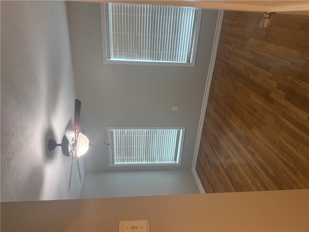 709 Churchill Drive Bryan, TX 77801 - Photo 10 of 31 a view of an empty room with wooden floor and a window