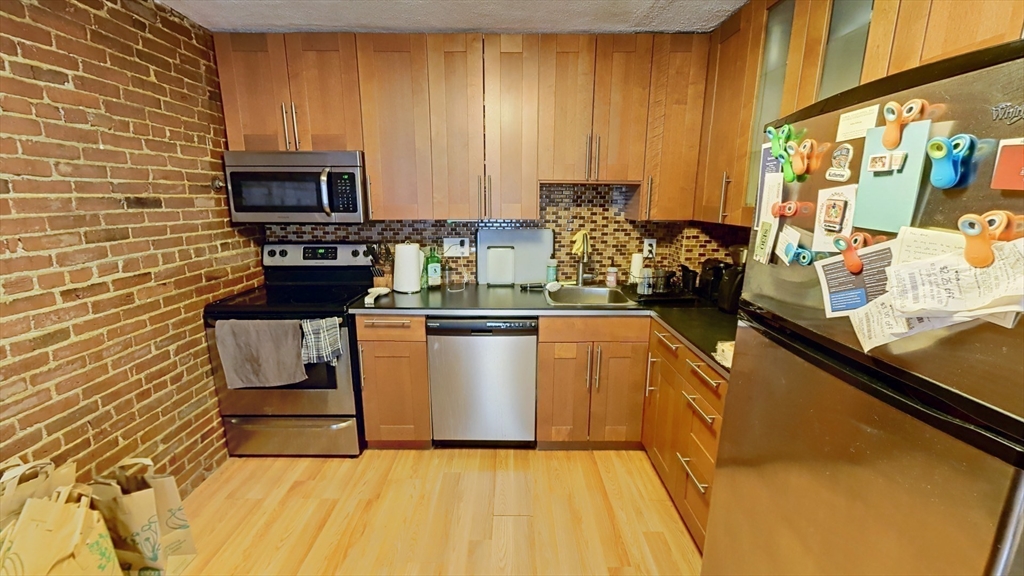 267 Main, Unit 3A Boston, MA 02129 - Photo 3 of 9 a kitchen with a sink a stove top oven a counter space and cabinets