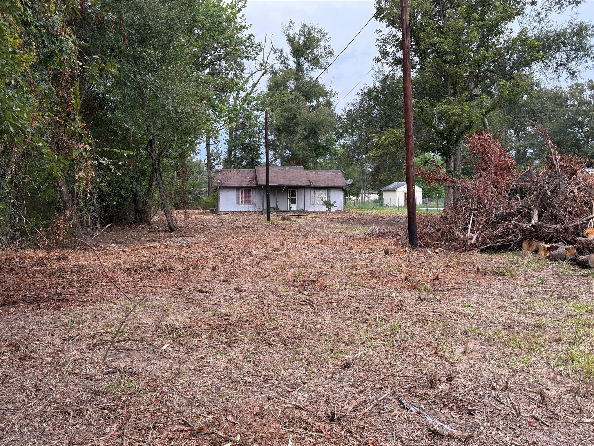 Cleared 0.92-acre property with existing improvements and partially wooded surroundings.