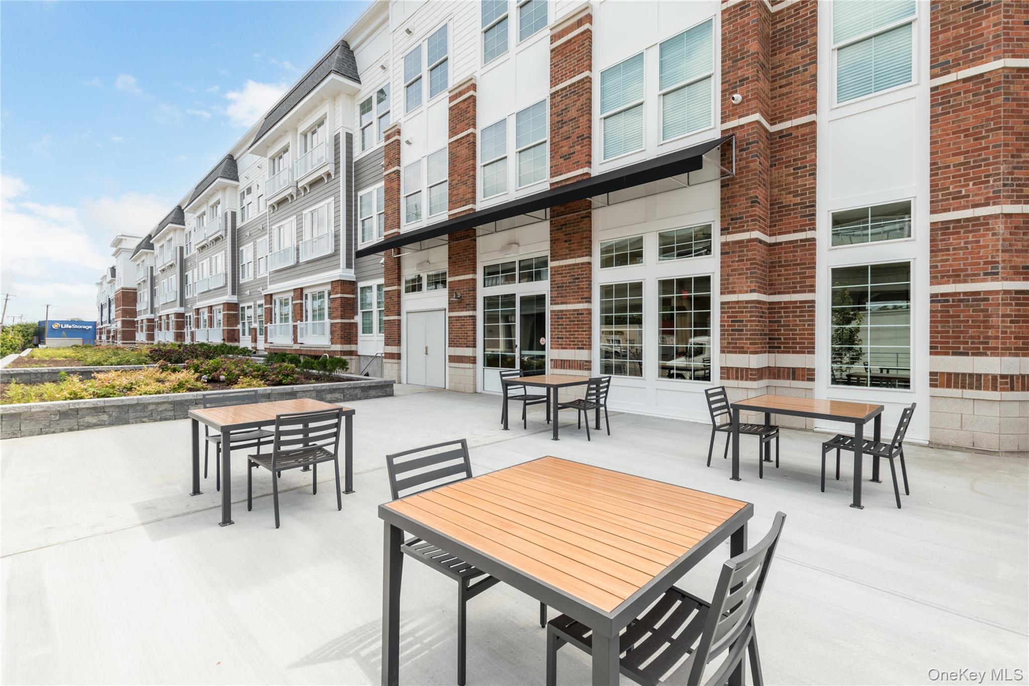 75 East Hoffman Avenue, Unit 4034 Lindenhurst, NY 11757 - Photo 6 of 7 a patio with table and chairs