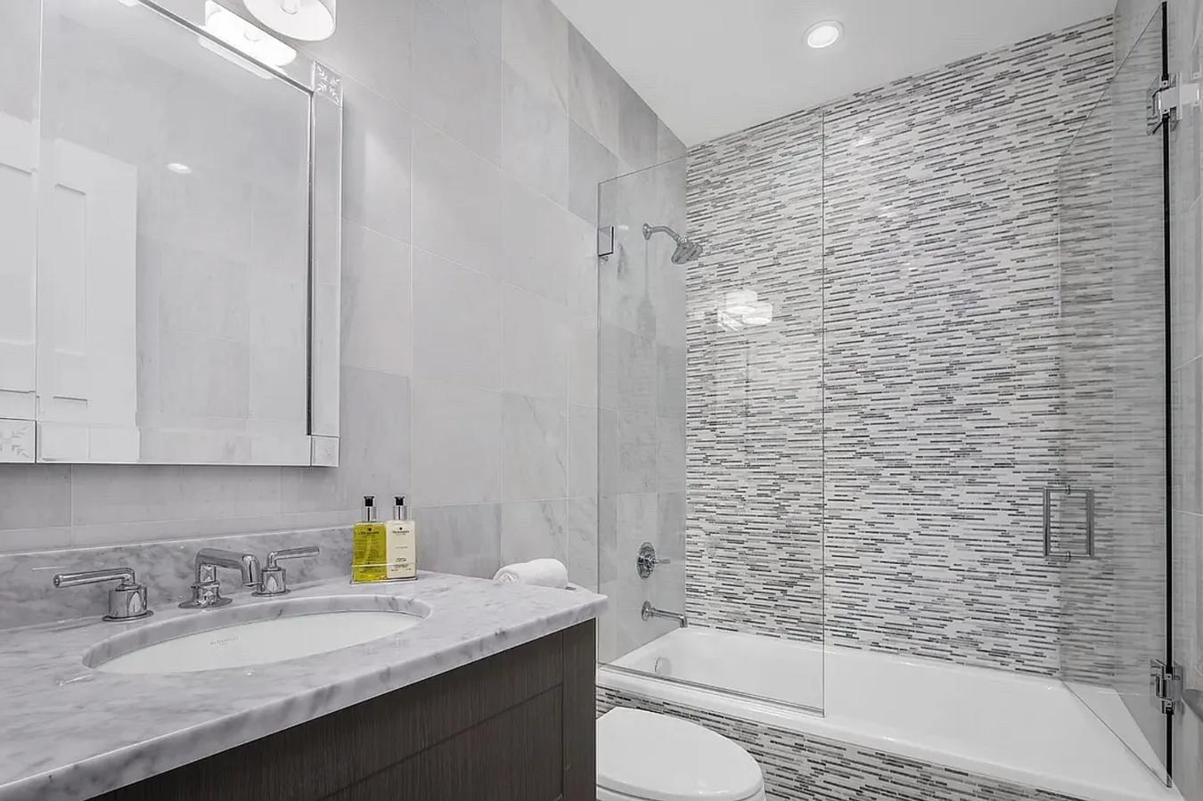 236 West 24th Street, Unit PH Manhattan, NY 10011 - Photo 11 of 14 a bathroom with a granite countertop bathtub sink vanity mirror and toilet