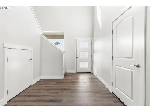 a view of an empty room with wooden floor