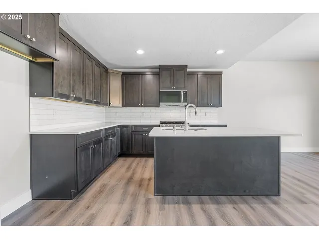 a kitchen with kitchen island sink stove and refrigerator