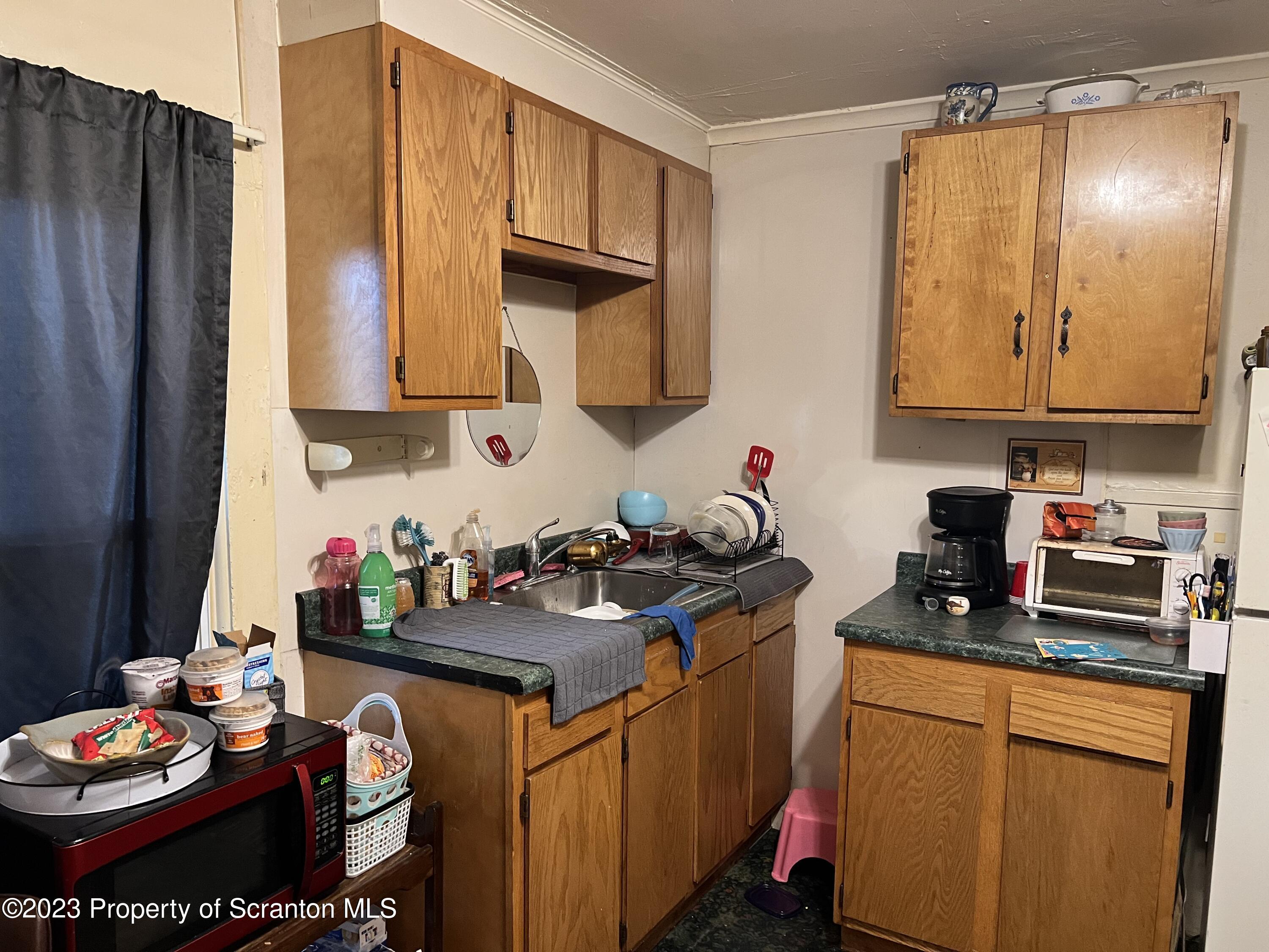 1613 Olive Street Scranton, PA 18510 - Photo 14 of 22 a kitchen with stainless steel appliances a sink a stove a refrigerator and cabinets