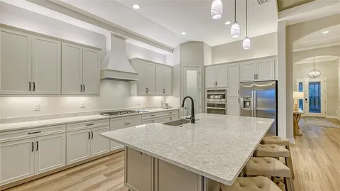 a kitchen with stainless steel appliances granite countertop a sink and a refrigerator