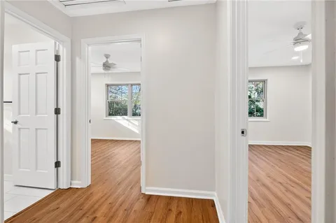 a view of a hallway with wooden floor and closet