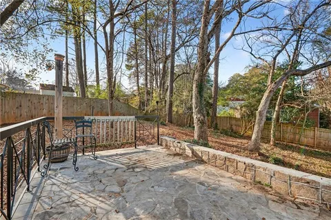 a view of a house with a large tree and wooden fence
