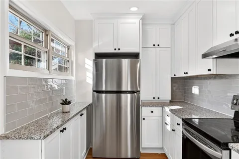 a kitchen with stainless steel appliances a refrigerator a stove a sink and dishwasher with wooden floor