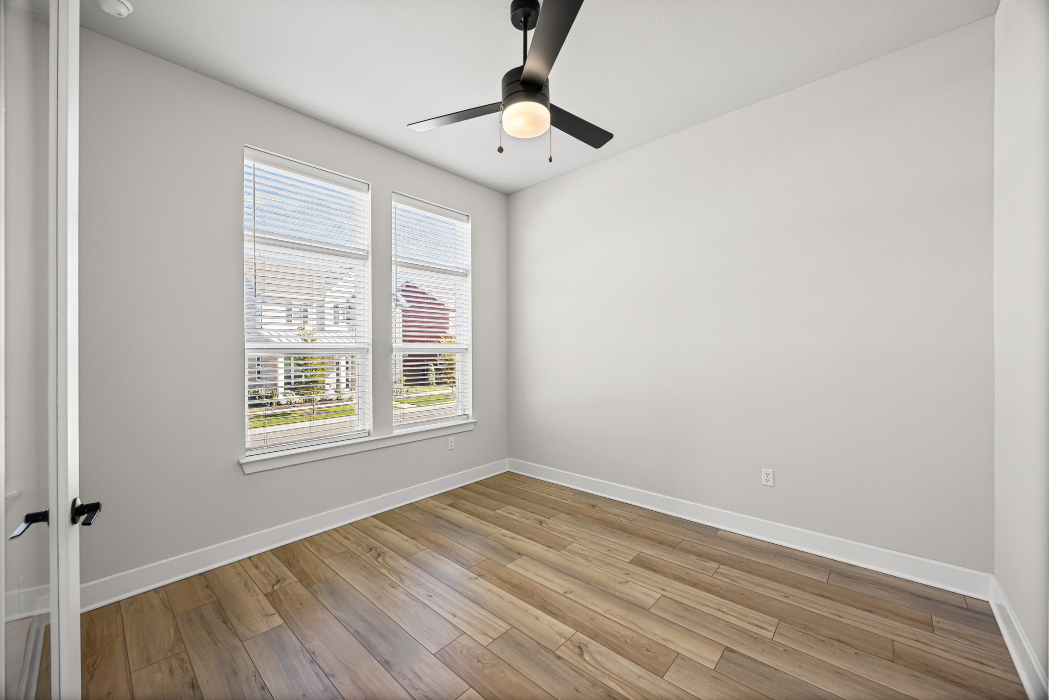 5806 Rangeland Road Austin, TX 78747 - Photo 10 of 34 A well-lit room showcasing a contemporary ceiling fan and durable wood-look flooring.