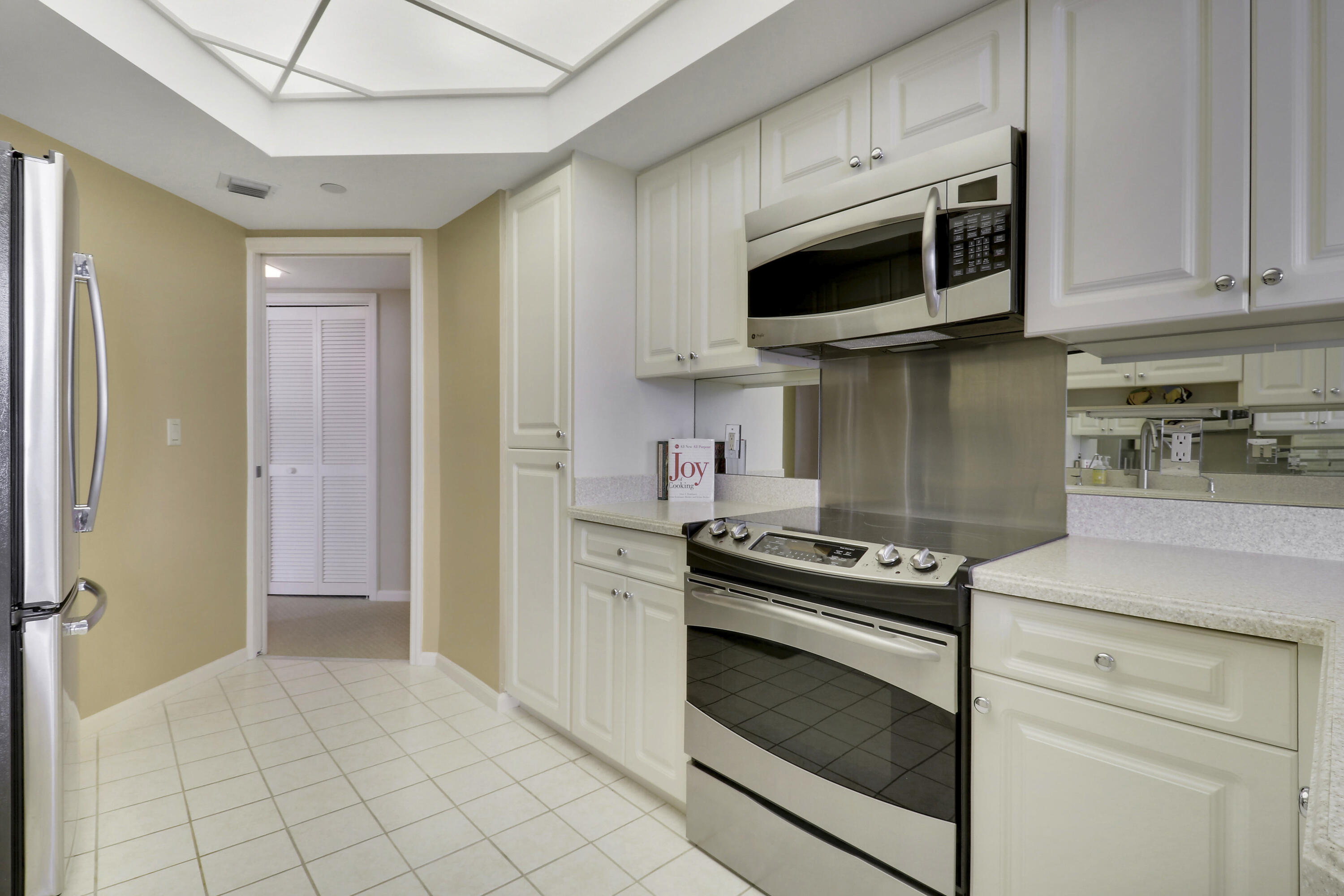3322 Casseekey Island Road, Unit 604 Jupiter, FL 33477 - Photo 19 of 55 a kitchen with stainless steel appliances a stove a microwave and cabinets