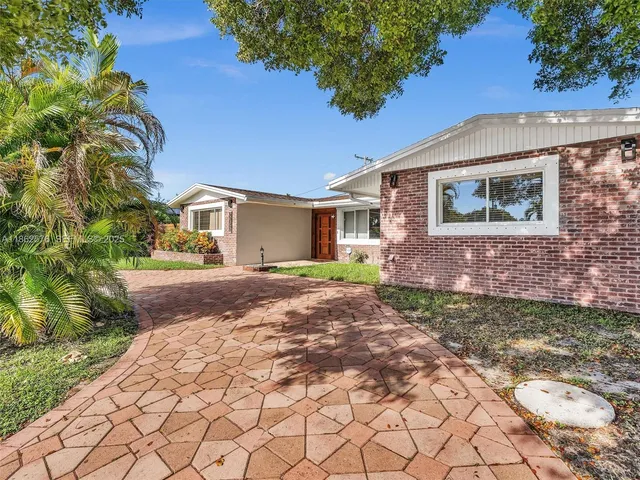 a living room with furniture a flat screen tv and kitchen view