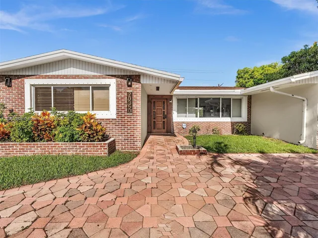 a dining room with furniture a chandelier and wooden floor