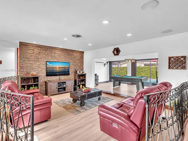 a view of a dining room with furniture a chandelier and wooden floor