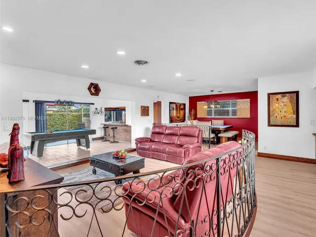 a kitchen with stainless steel appliances granite countertop a refrigerator a stove and a sink with wooden floors