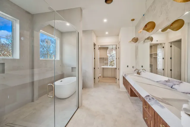 a spacious bathroom with a double vanity sink a mirror and a bathtub