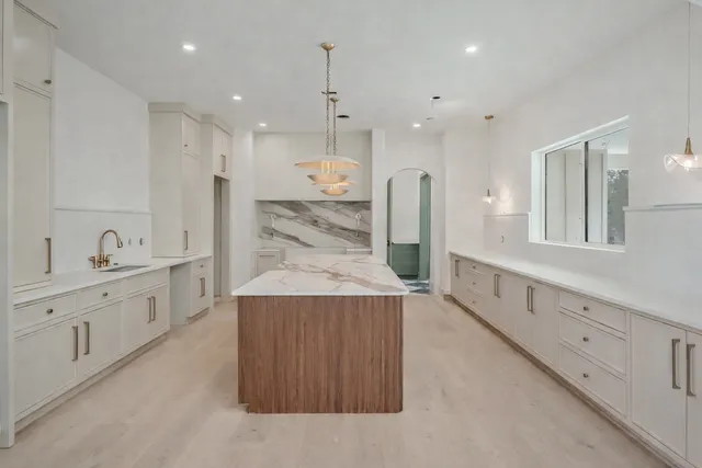 a kitchen with a stove a sink a center island and a cabinets